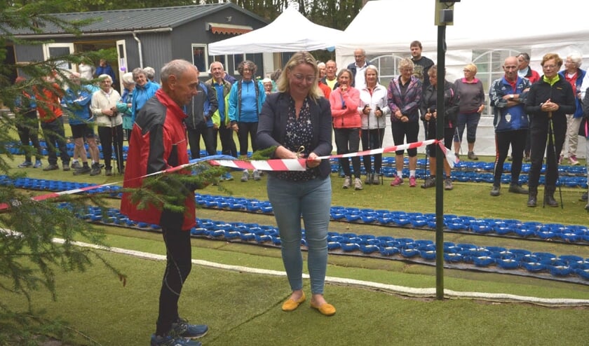 Wethouder Verkuijlen knipte het lintje door samen met links Harrie van der Heijden, een medewerker van de Baan- en materialencommissie. Deze commissie heeft de afgelopen zomer de schietpalen en de overkapping gebouwd.