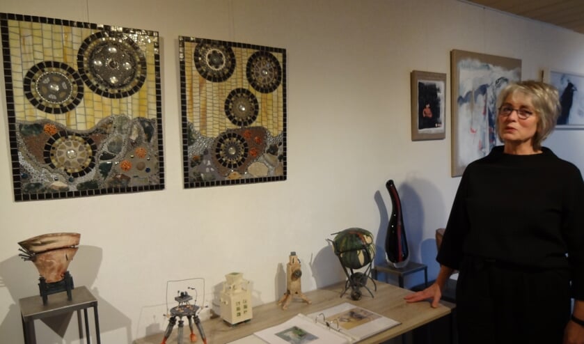 Marion de Goeij bij een gedeelte van haar werk. Aan de wand mozaïeken van Marga Janssen. (foto: Ankh van Burk)