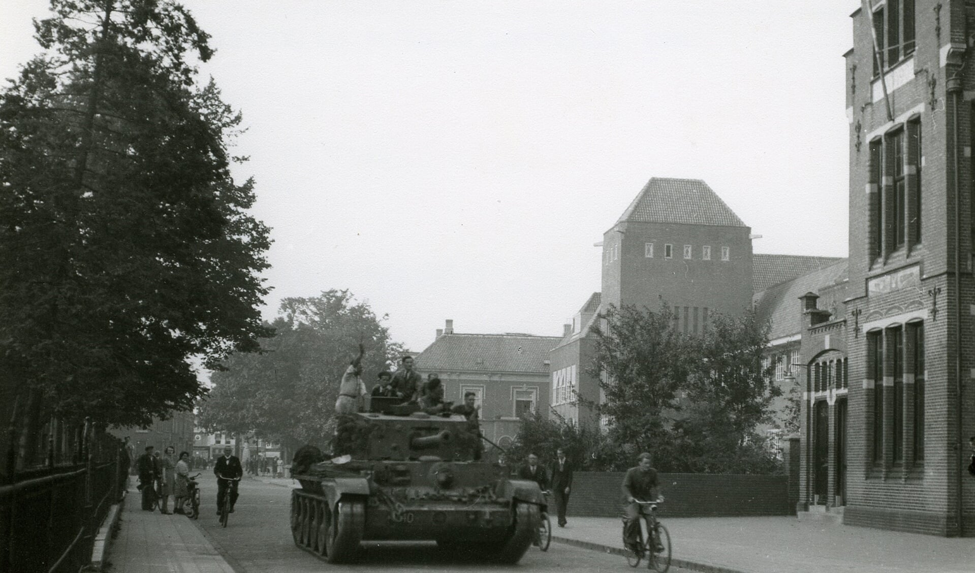 Een Britse tank rijdt op 19 september 1944 door de Molenstraat, ter hoogte van het toenmalige postkantoor. Verschillende leden van het verzet rijden op de tank mee om de weg te wijzen. Foto: Leo van den Bergh, collectie Stadsarchief Oss