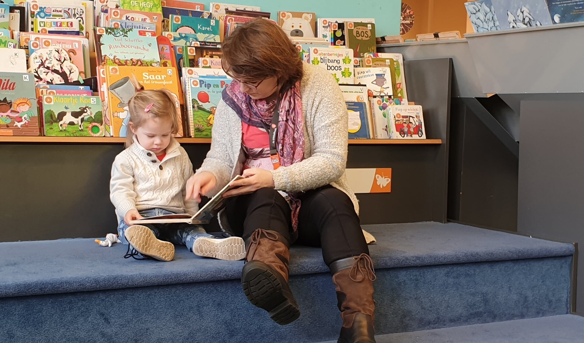 Moeder en dochter genieten van verhalen in bibliotheek Boxmeer.