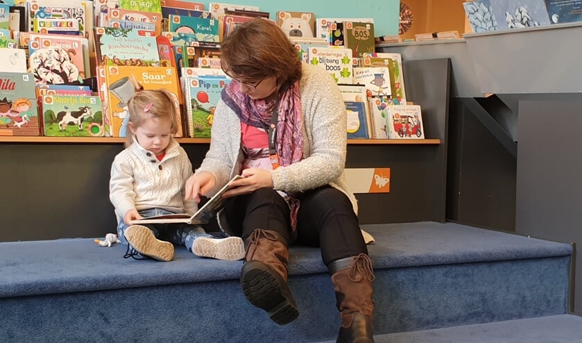 Moeder en dochter genieten van verhalen in bibliotheek Boxmeer.
