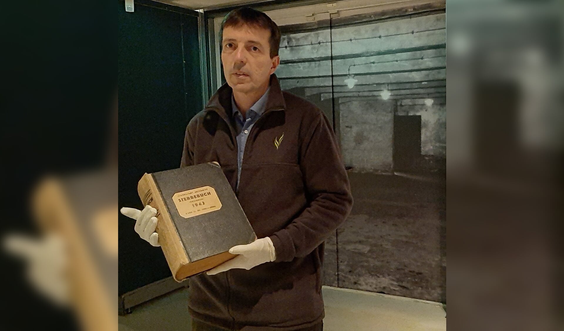 De directeur van het Oorlogsmuseum in Overloon met het Dodenboek van Auschwitz.