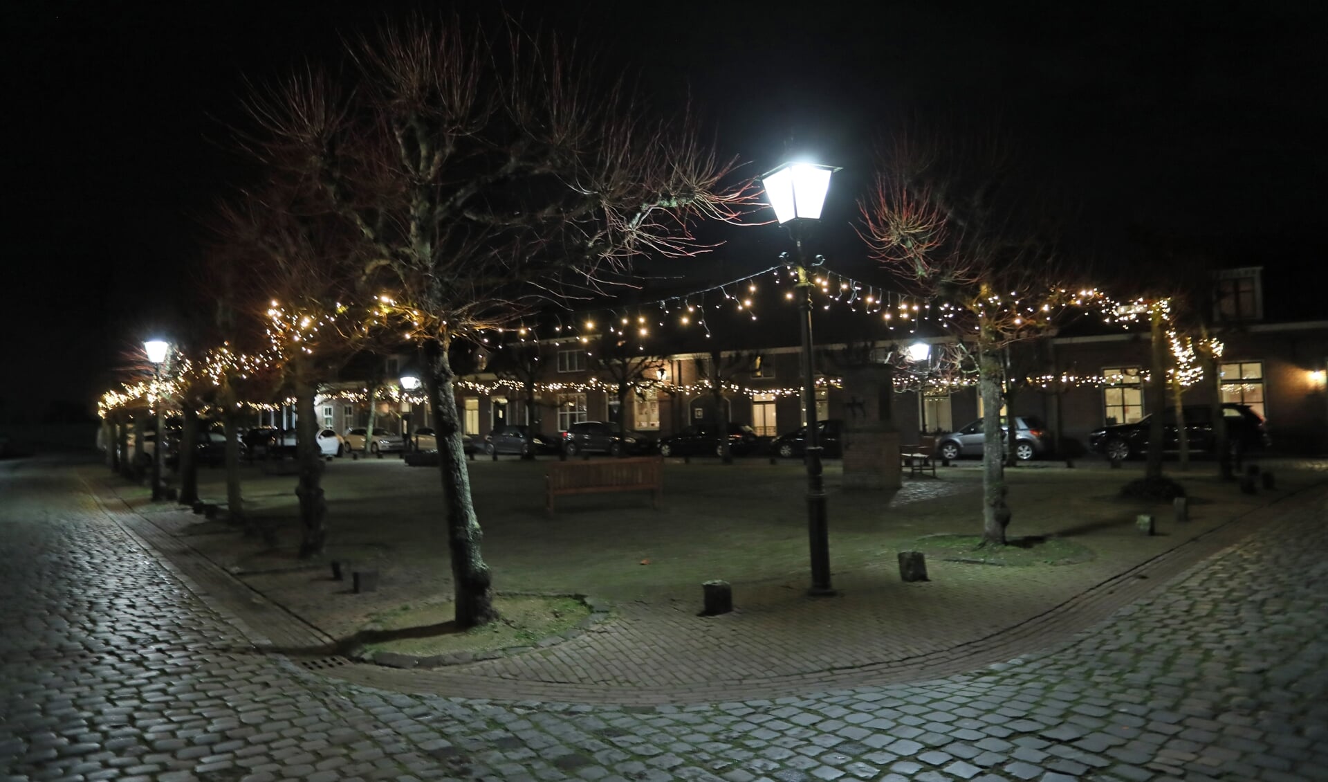 Een plein in Megen met kerstverlichting.