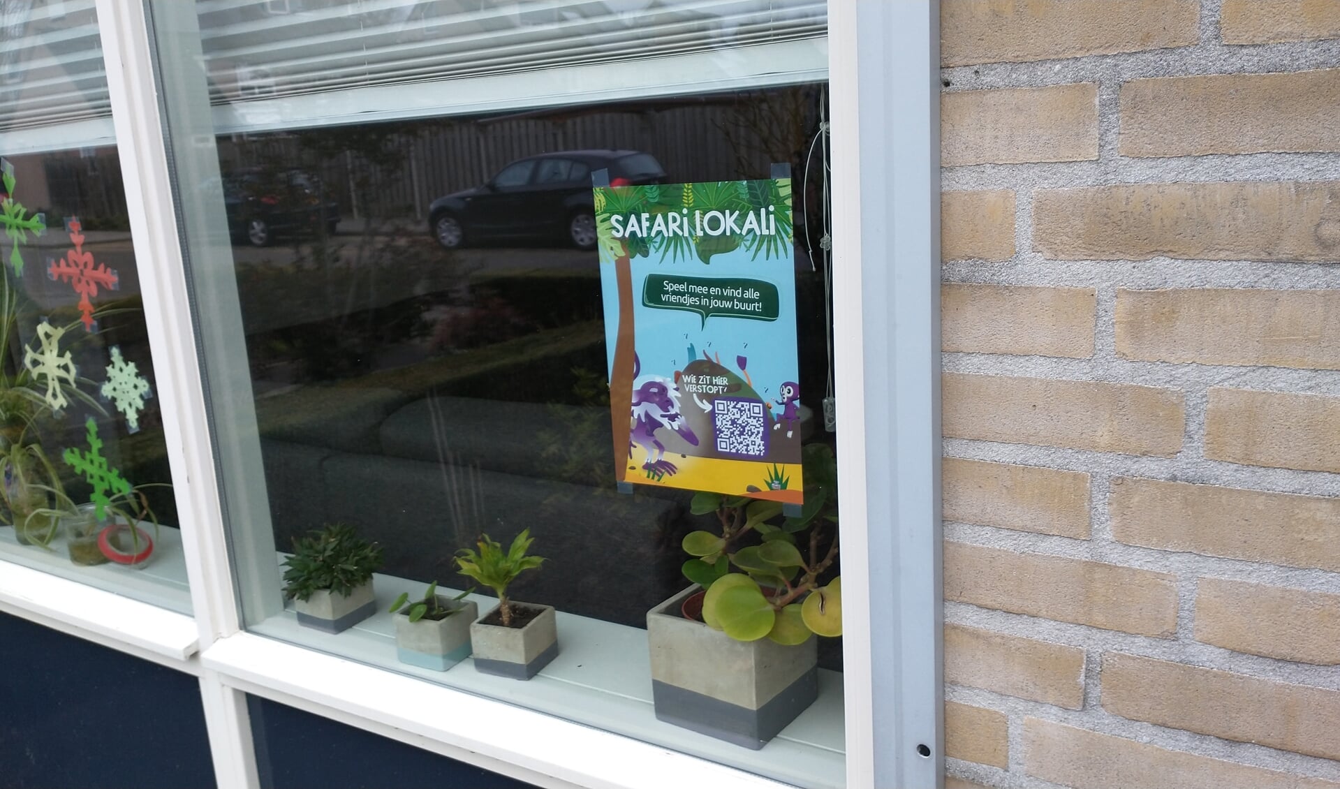 De Safari Lokali poster bij Laura Welten achter het raam. Hang jij er (samen met jouw buurt) ook één op? 