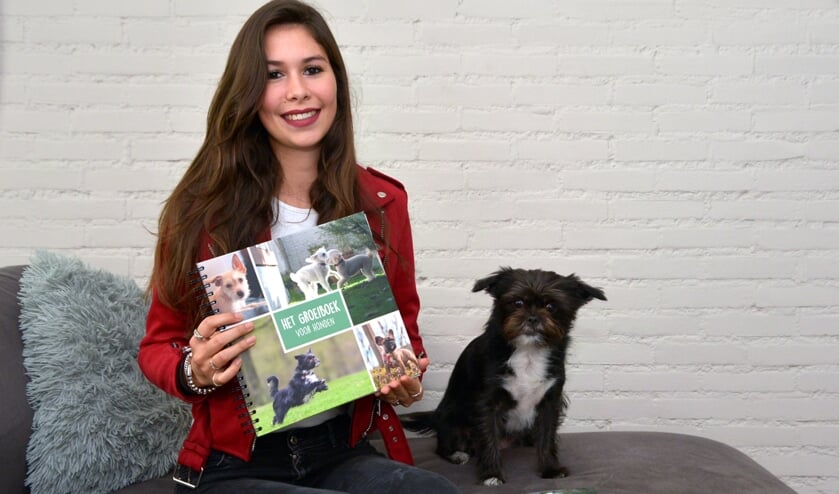 <p>Een trotse Joy met haar boek in haar handen en haar hondje naast haar. (foto: Henk Lunenburg)</p>  