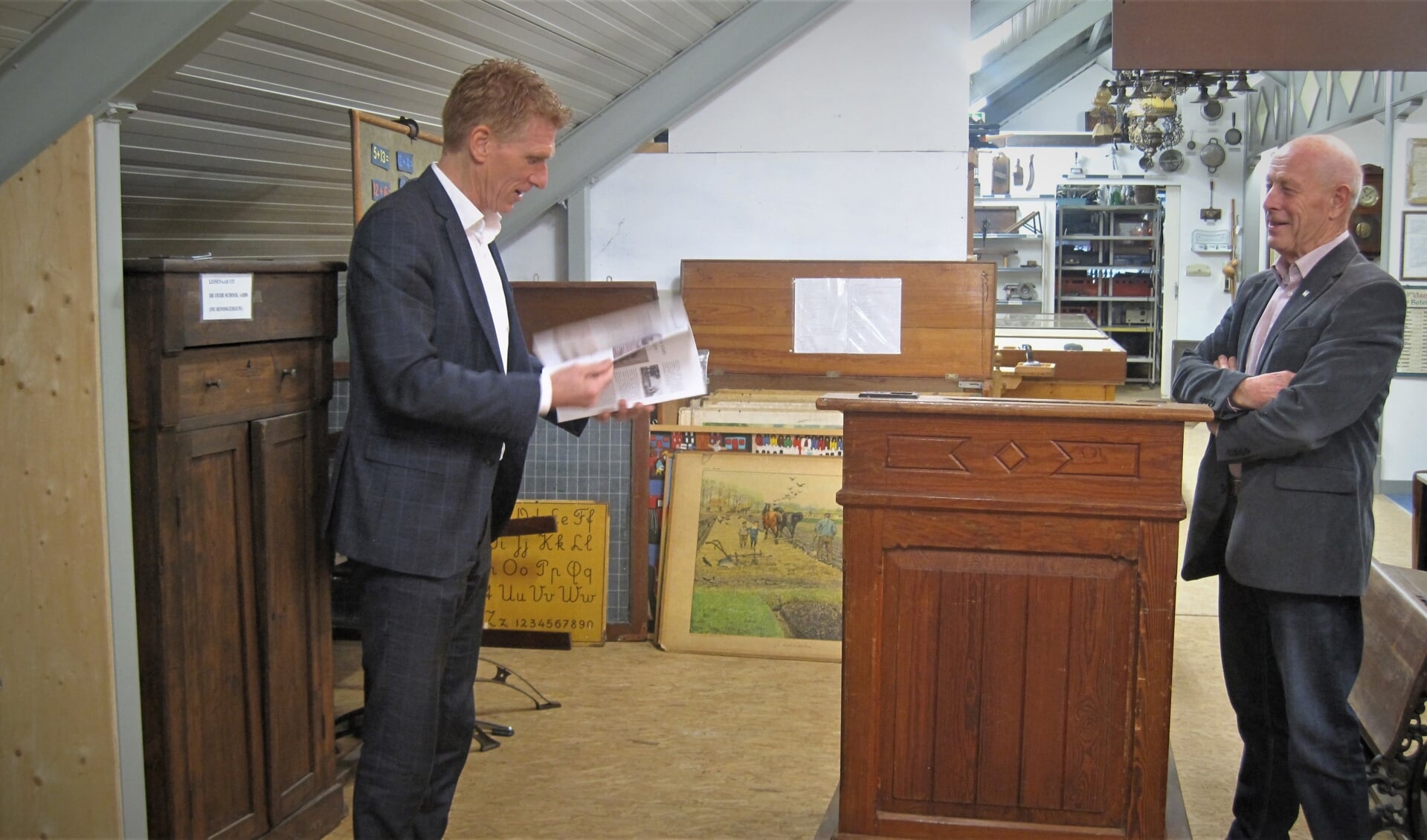 Burgemeester Marnix Bakermans bladert door het nieuwe tijdschrift van heemkundekring Zeeland. Rechts voorzitter Gerard Selten. (foto: Heemkundekring Zeeland) 