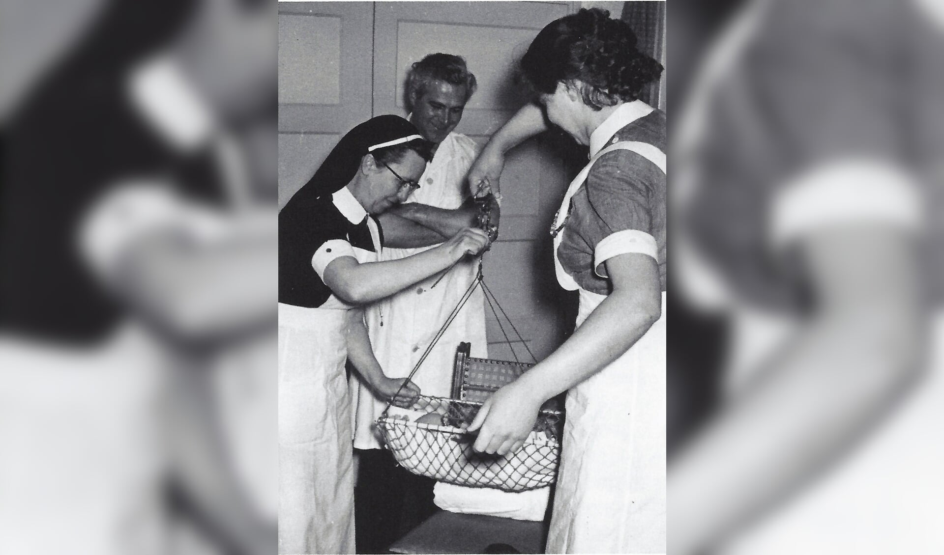 Zuster Van Uffelen (links), docente van het Kraamzorgcentrum in Veghel met de arts Van Kuppevelt (midden) en een kraamverzorgster in 1956.