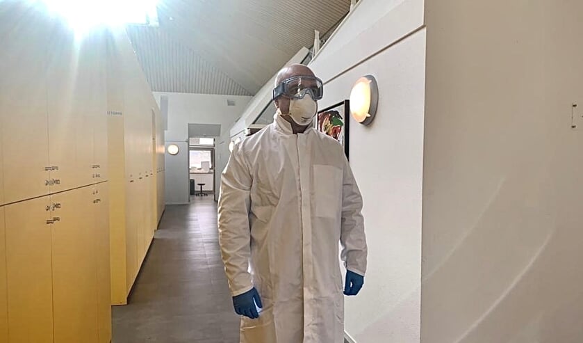 De Veghelse huisarts Milan Poucki met bril, handschoenen en mondkapje.