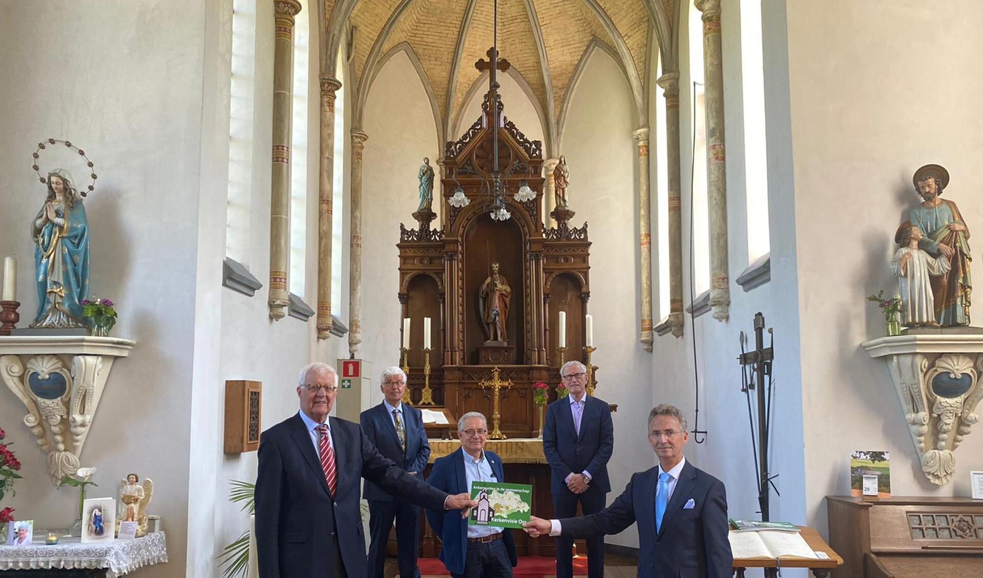 De stuurgroep biedt de Kerkenvisie Oss aan aan de gemeente Oss in de Sint Jan de Doperkerk in Neerlangel. 