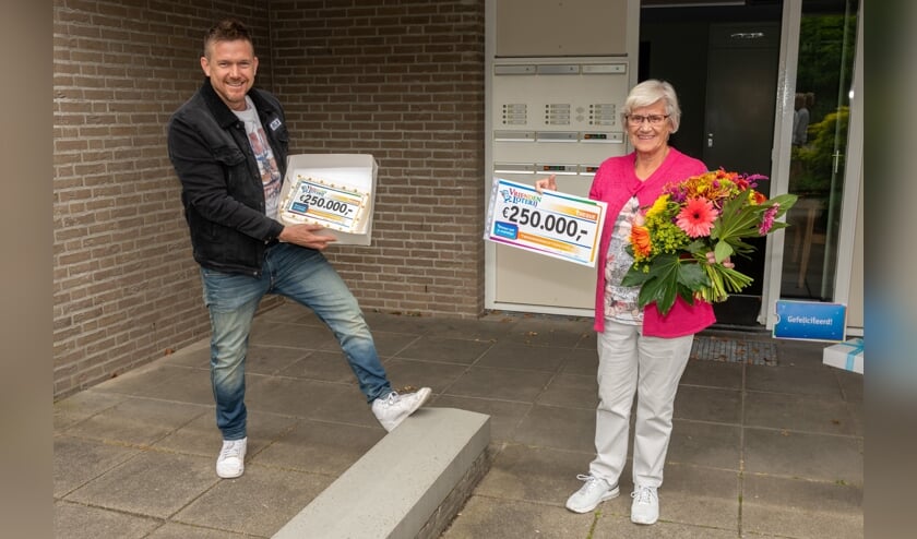 Johnny de Mol reikt de cheque uit.
