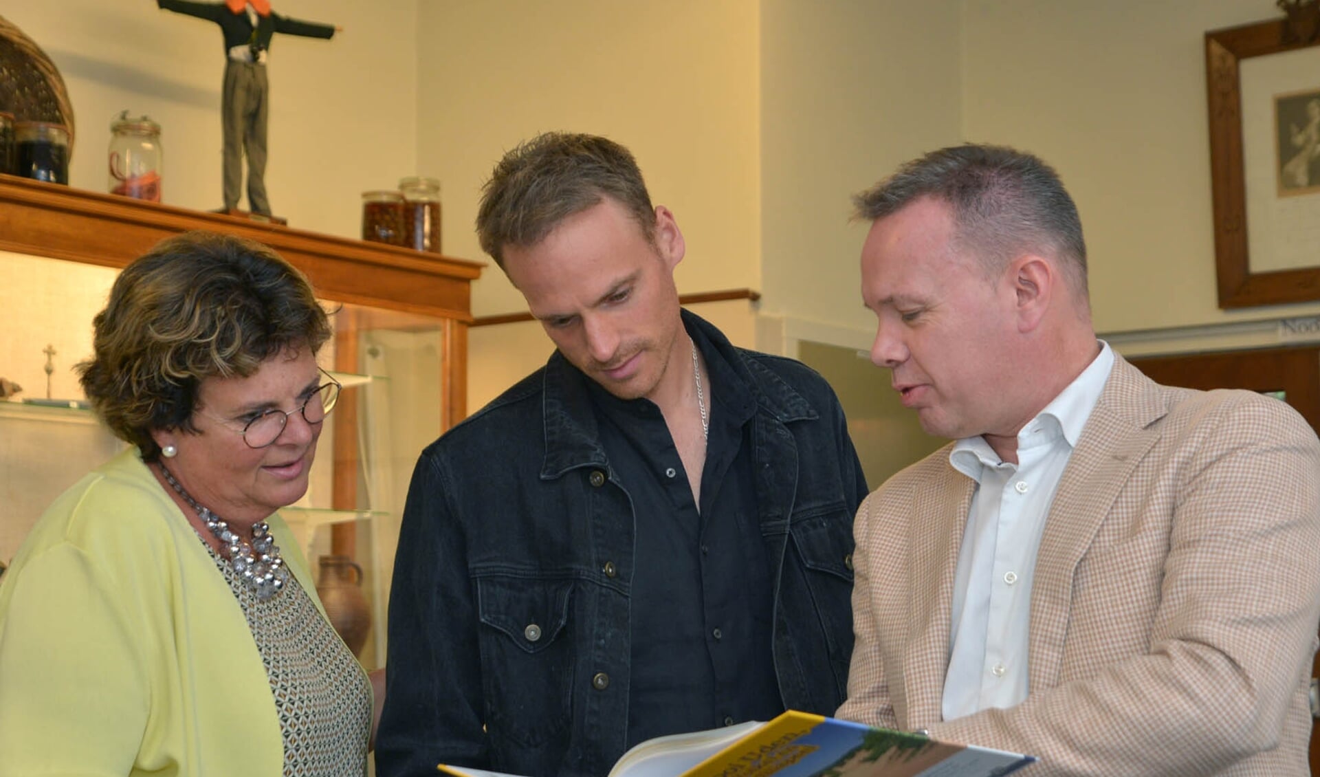 Annemieke de Groot, Giel de Winter en Roland de Laak bekijken het boek. (foto: Henk Lunenburg)
