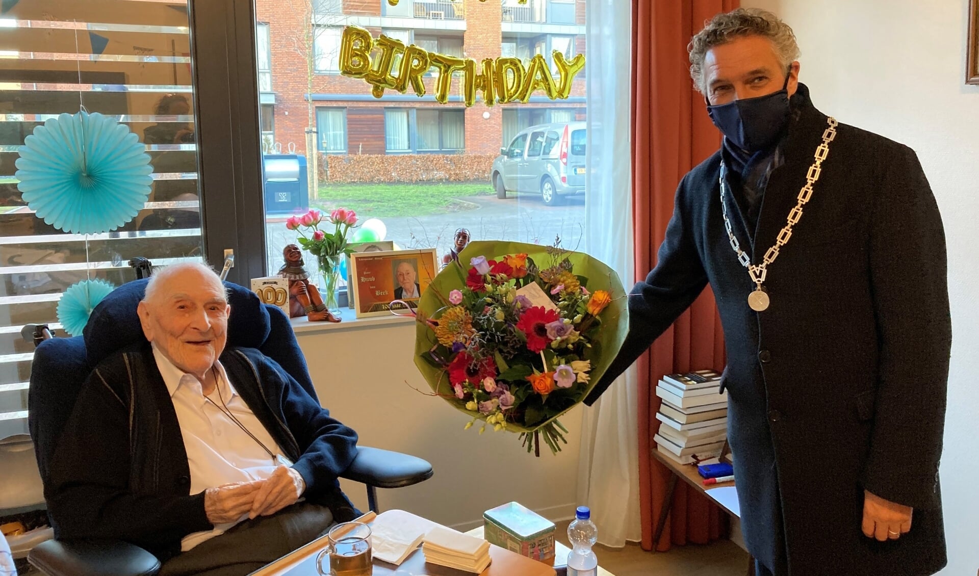Burgemeester Teunissen feliciteert 100-jarige pater.