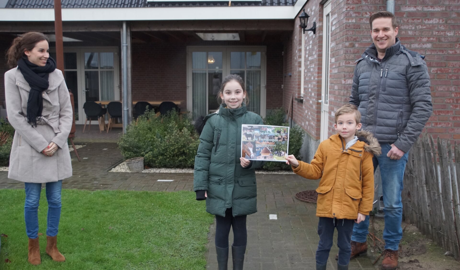 De familie Vos-Van Sambeek ontvangt hun prijs van melkveehouder Rob Wientjes. 