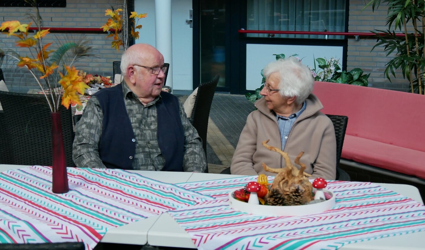 Adriaan en Diny zitten samen in de binnentuin: 'Nergens vind je zo'n mooi seniorencomplex als hier.'