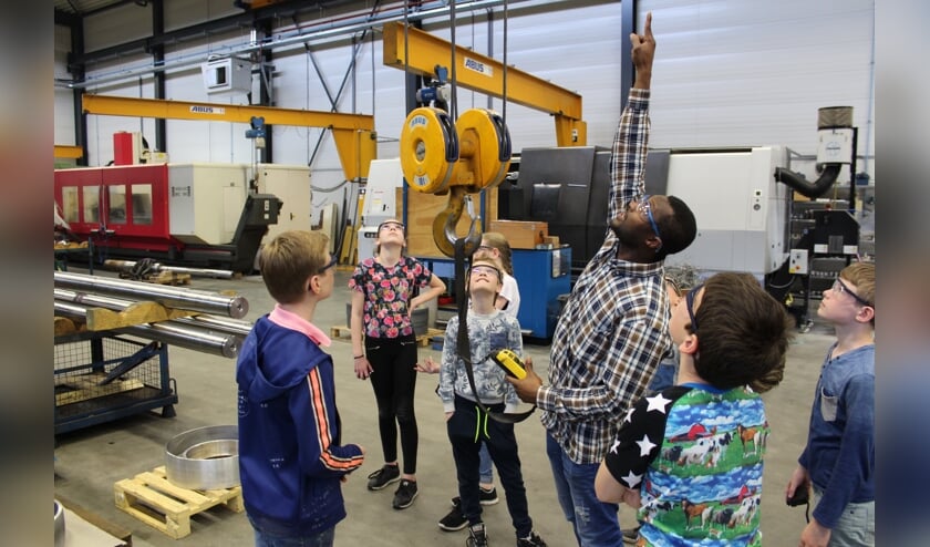 <p>Kinderen krijgen uitleg over de werking van een hijstoestel.</p>
