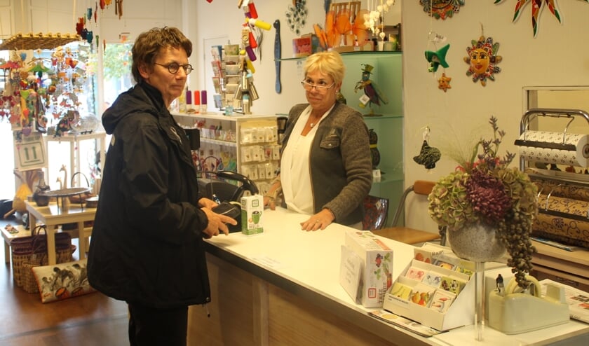<p>Voorzitter van de Wereldwinkel Wilma van Asseldonk (L) in gesprek met collega-vrijwilliger Cora.</p>