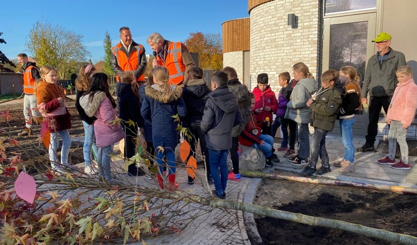 De in oranje hesjes gestoken wethouders Janssen (l) en Peperzak (r) spreken de kinderen toe.