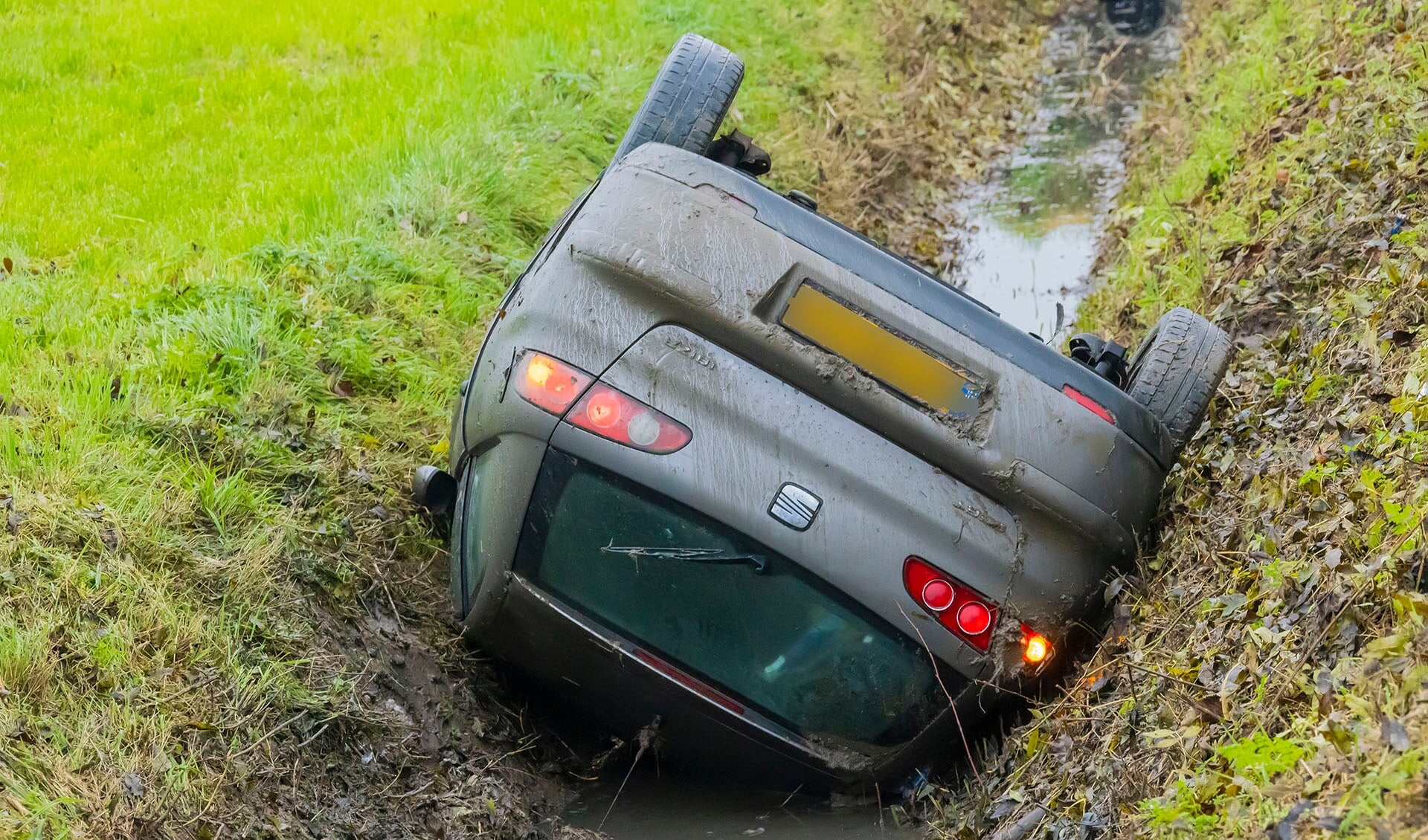 Auto komt in Lithoijen op zijn kop in een sloot tot stilstand. (Foto: Charles Mallo, Foto Mallo)