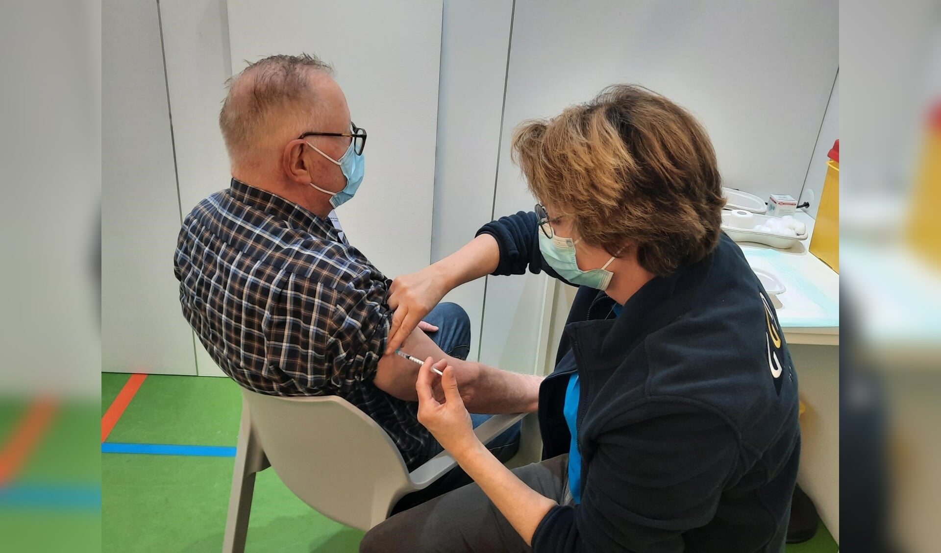 Meneer Verouden wordt gevaccineerd in Sportcentrum Berghem.