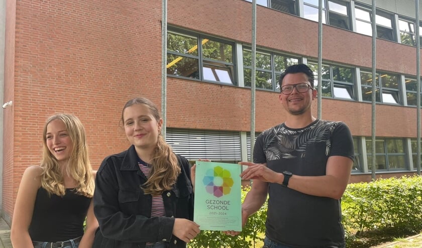 <p>Leerlingen Quinty en Lotte, en docent/coördinator Jos tonen de plaquette Gezonde School. Patricia maakte de foto.</p>