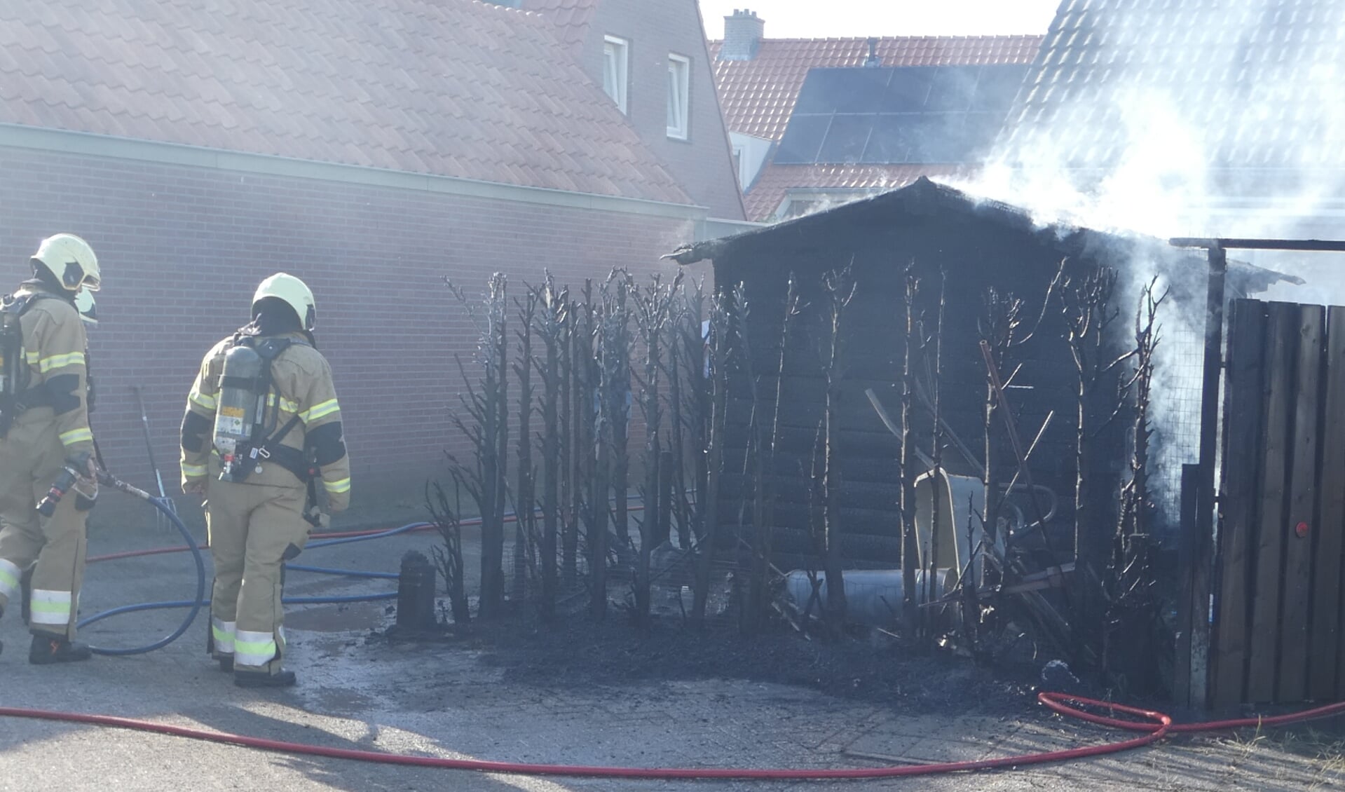 Brandweer blust brandende haag en schuur in Heesch. (Foto: Thomas)