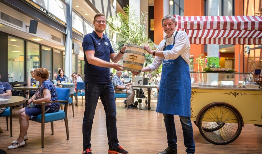 <p>Op de foto: Thomas van der Cammen (links, Bewegingsagoog BrabantZorg) neemt eerste haringvaatje in ontvangst van Ron Koks (National Accountmanager SmitVis).</p>