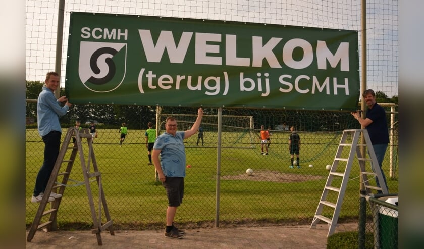 <p>Ruud vd Sanden, Rick vd Biggelaar en Will Kemps hangen het spandoek op zodat het ook zichtbaar is: Welkom (terug) bij SCMH.<br><br></p>