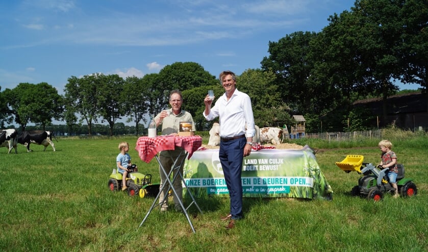 Foto: Marien Borgstein en Ronald Meijers heffen een glas melk op de samenwerking. Cas en Nils Wientjes kijken toe.