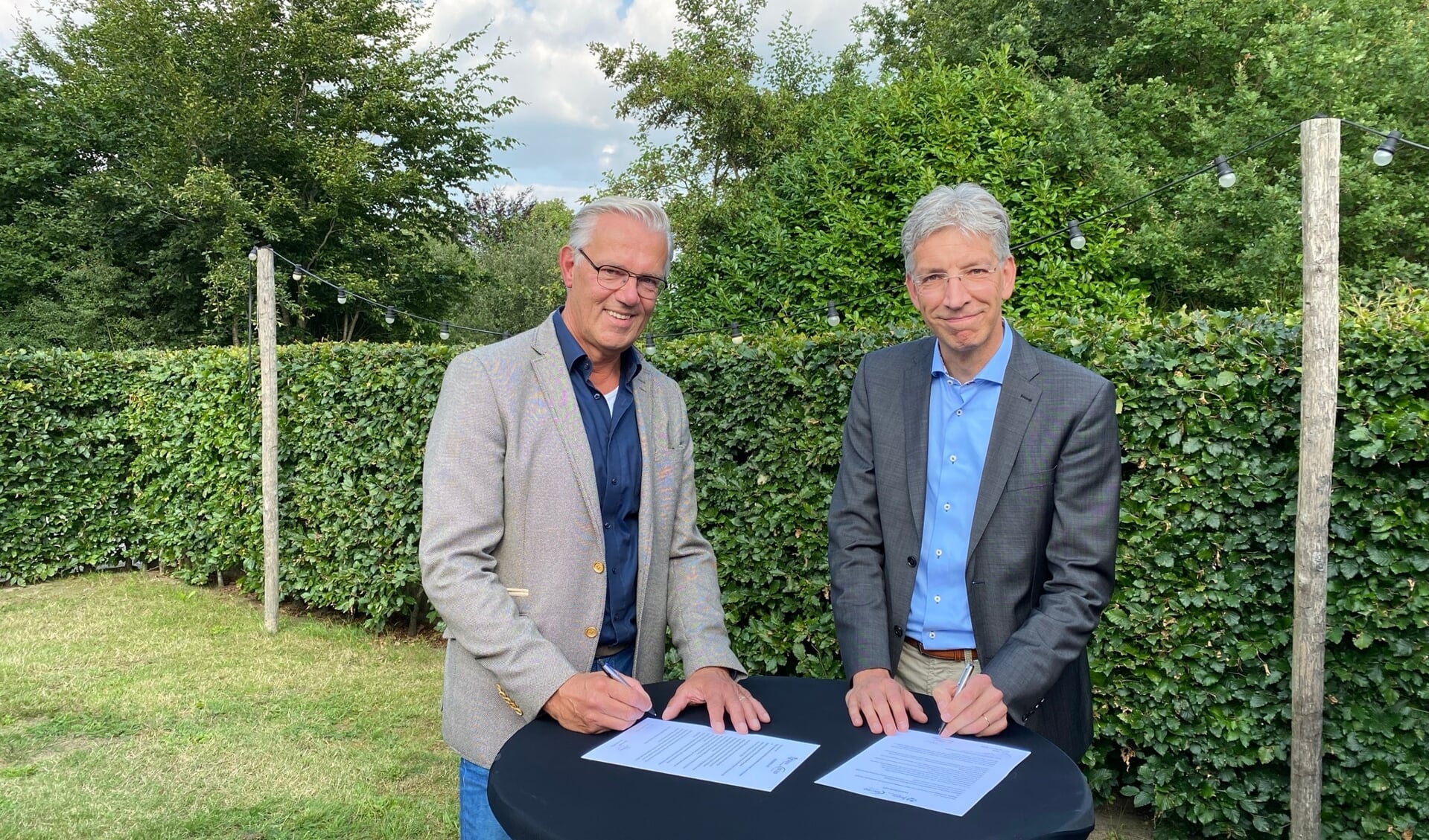 Berry Tomas (L) en Paul Meessen (R) ondertekenen het fusiebesluit.