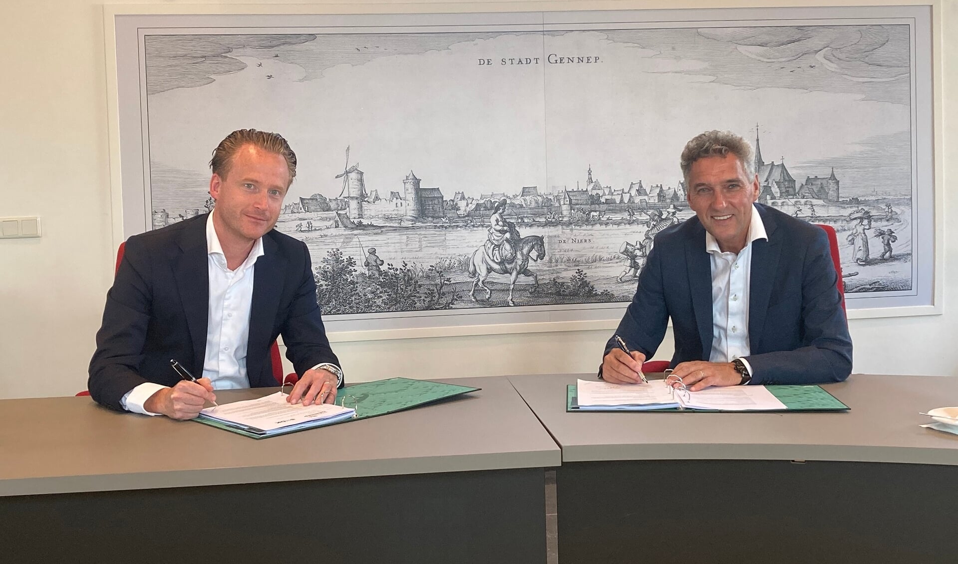 Mark Janssens van SDK Vastgoed en burgemeester Hans Teunissen tekenen de overeenkomst grondverkoop Gennepermolen.