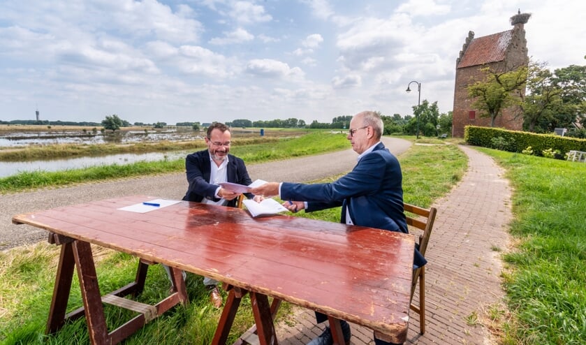 <p>Mario Jacobs en Maar van Oord zetten hun handtekening.</p>