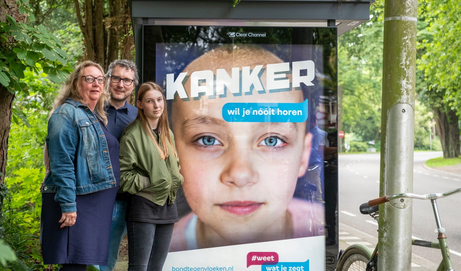 De ouders en de zus van de overleden Anne bij de poster Kanker wil je nóóit horen.