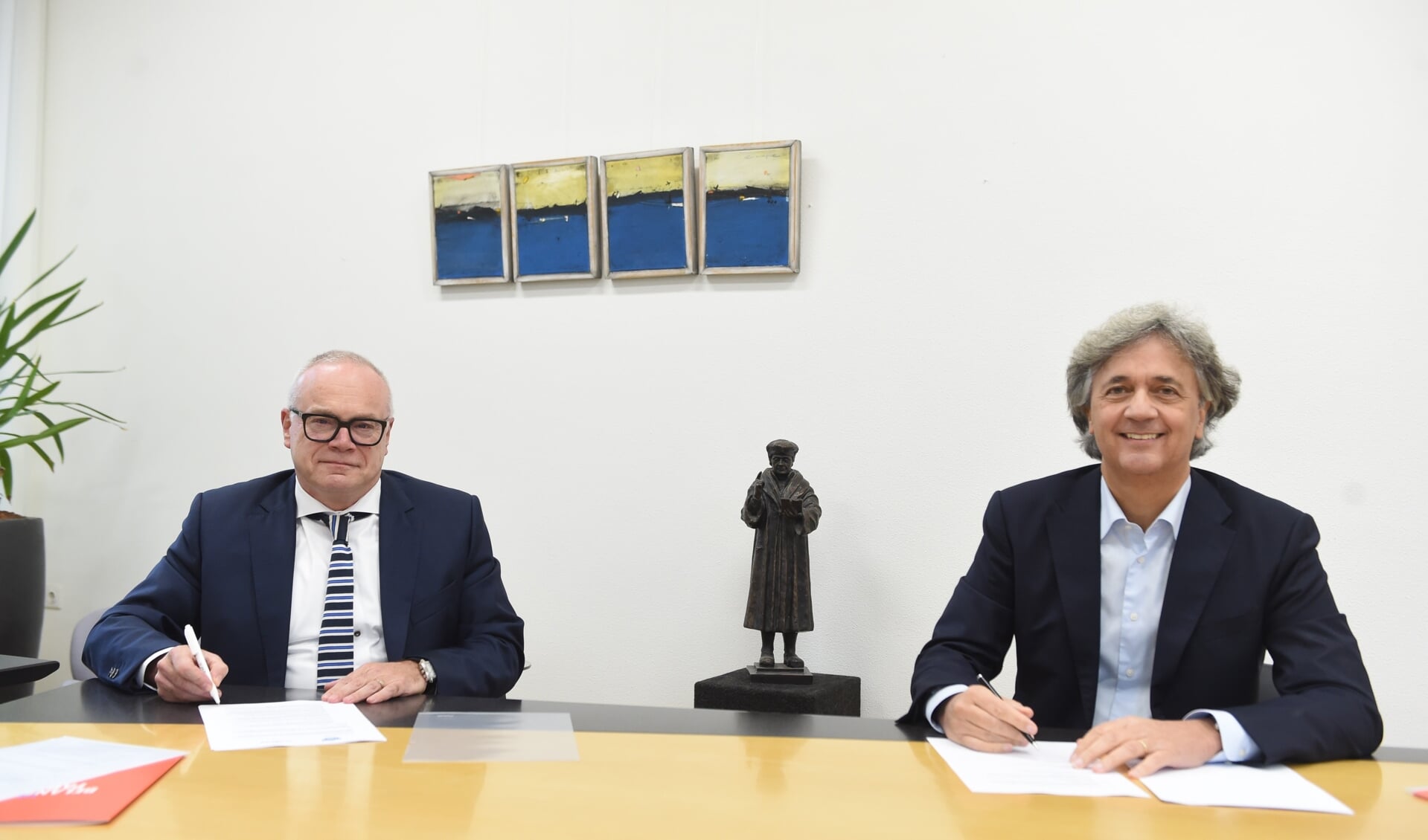 Peer van Summeren en Jos van Kessel (Koning Willem I College) ondertekenen de fusie-intentieverklaring.