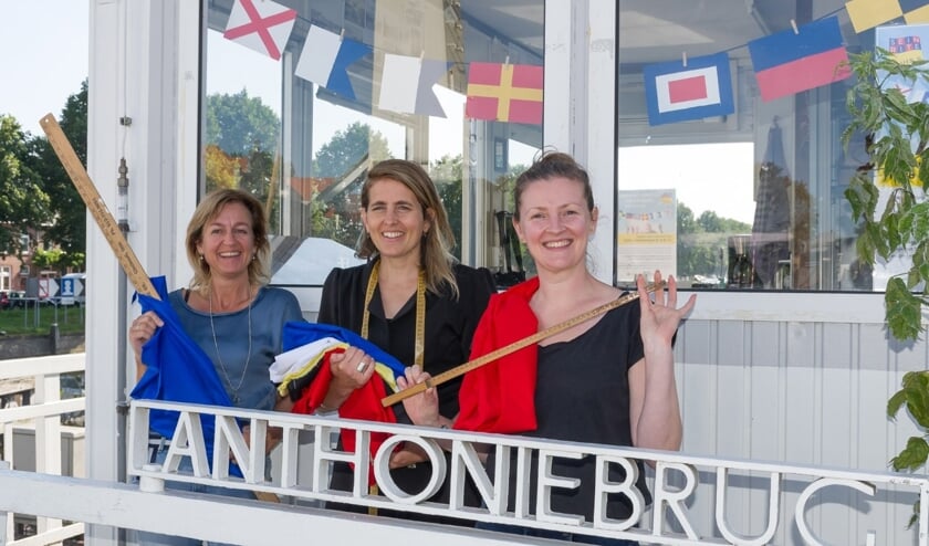 <p>Inmiddels hebben 25 vrijwilligers al 148 seinvlaggen genaaid voor de Seinrite Sluis0. Op de foto Elise Swietkowia (Bij Katrien), Marij Gravestein (projectcoördinator) en Wies van Aken (buurtbewoner). (Foto: Peter Ekels) </p>