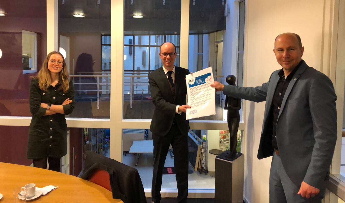 Cyril Crutz (BiblioPlus) en Silke Walraven (Stichting Lezen & Schrijven) hebben het manifest uitgereikt aan wethouder Joost Hendriks (midden).