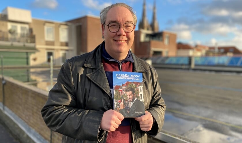 Rick Jacobs, met in zijn hand zijn derde boek 'Bart Da-Mooy, Moord in vooruitzicht'.
