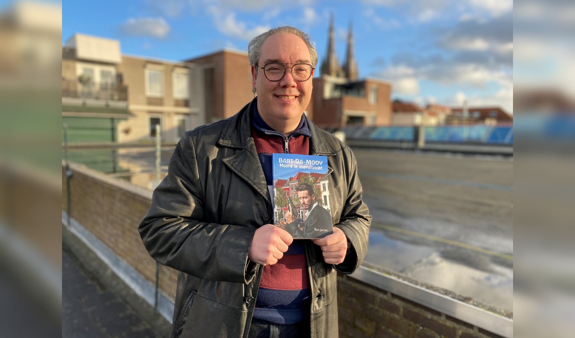 Rick Jacobs, met in zijn hand zijn derde boek 'Bart Da-Mooy, Moord in vooruitzicht'. 