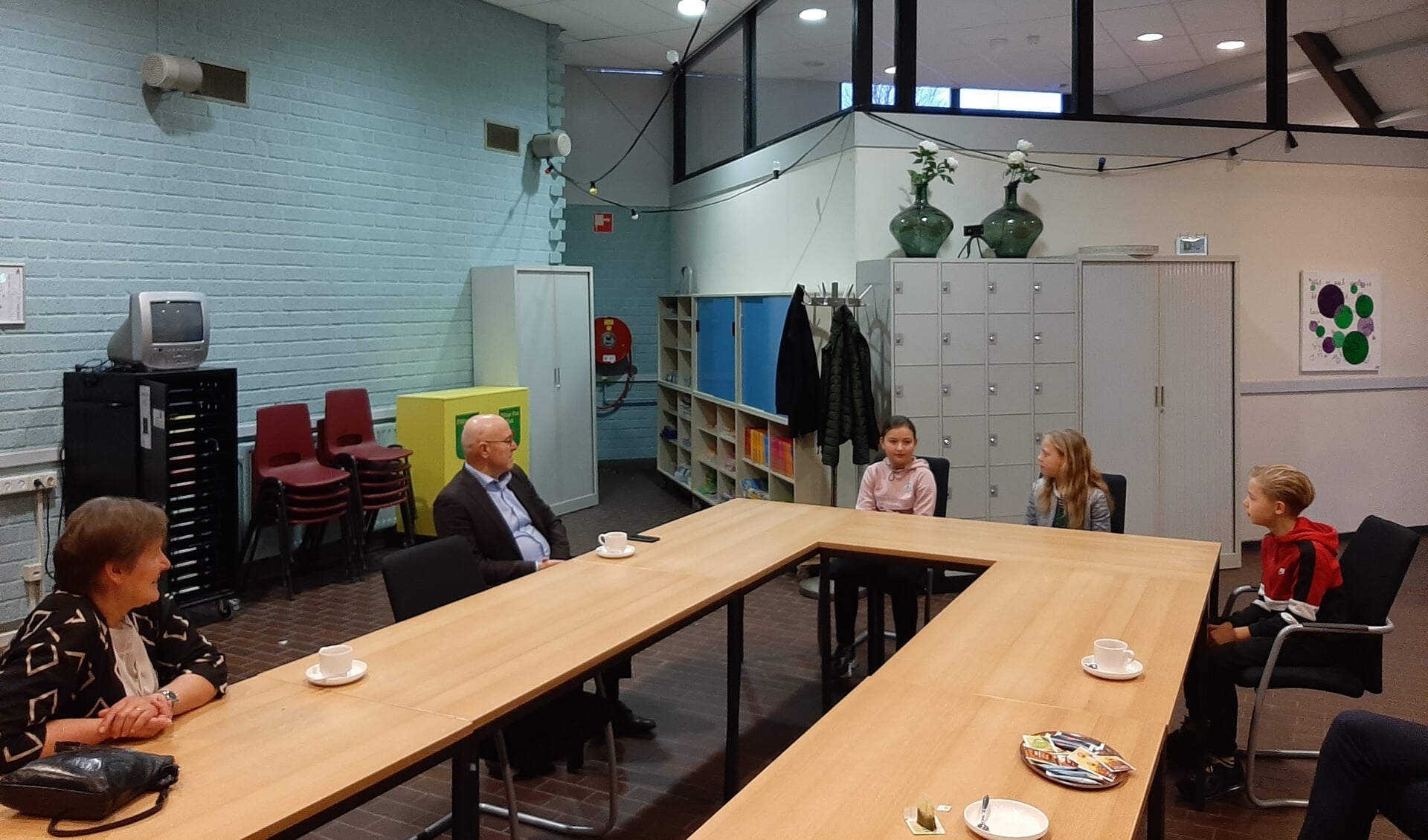 Wethouder Van der Pas en Kees van Rooij in gesprek met Dexter, Evi en Jara. Zij zitten alle drie in groep 8 van basisschool De Bunders.
