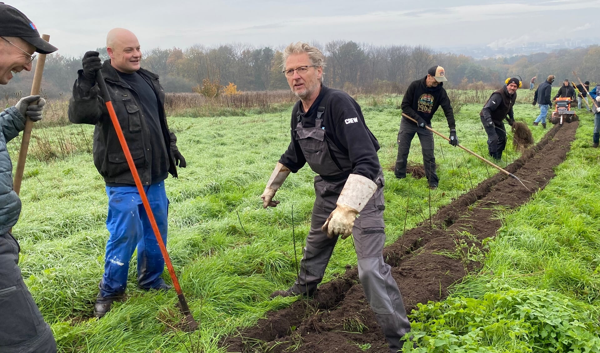 Bestuurslid Peter Mak van Stichting Mountainbike Rijk van Nijmegen in de weer om de haagplanten in de grond te plaatsen.