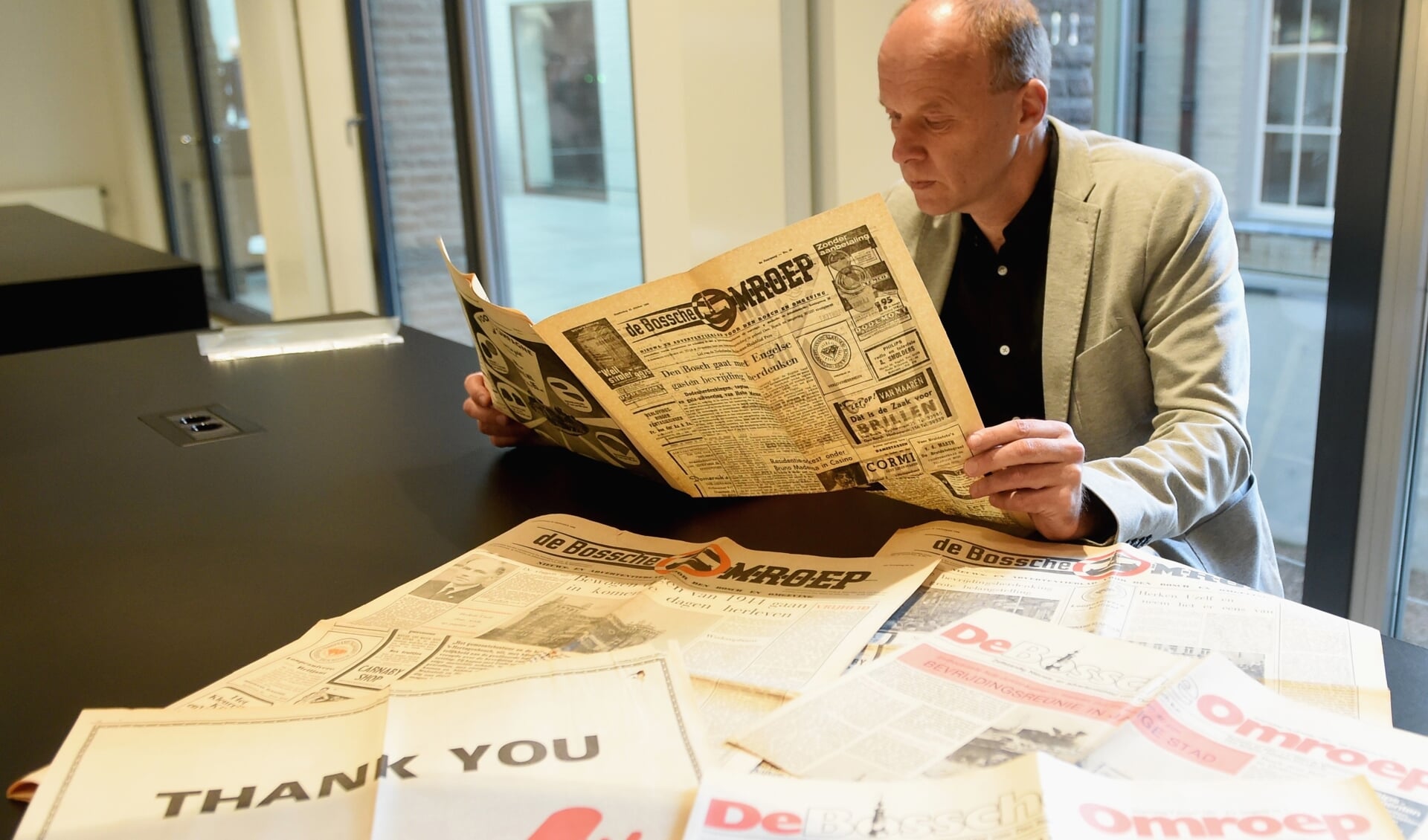 Jan de Wit met een aantal kranten uit zijn archief.