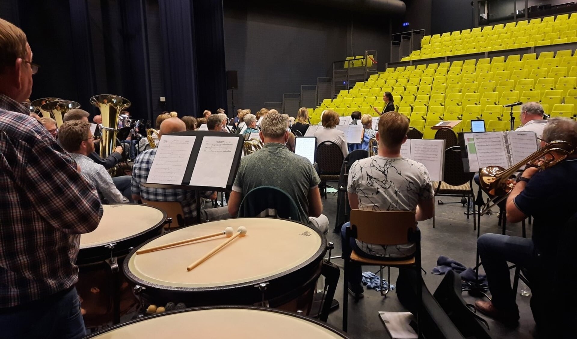 Het orkest aan het repeteren, met z'n allen in de grote - nu nog lege – concertzaal.