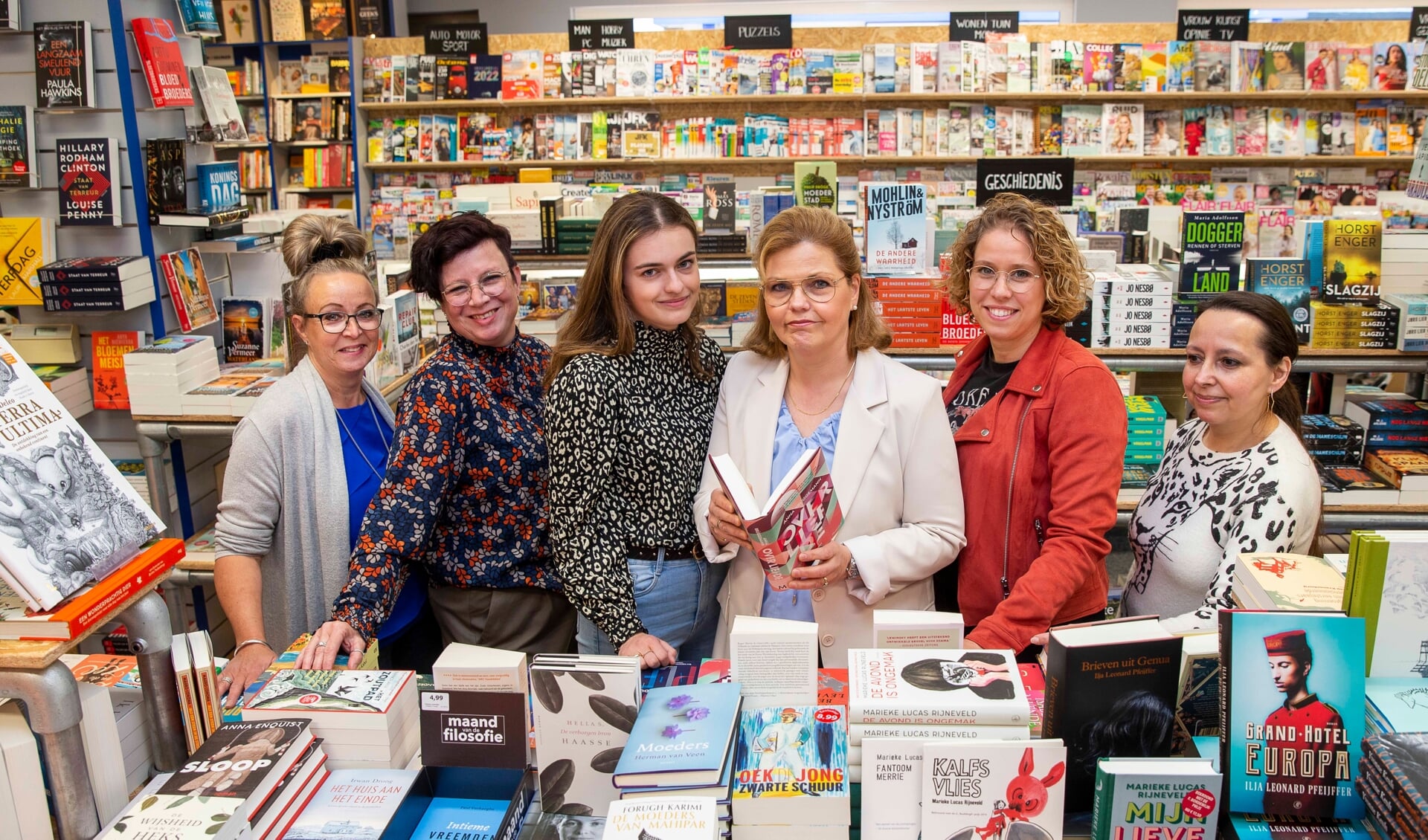 Annemarie Schellen (met boek) samen met haar dochter (links van haar) en een gedeelte van het Boekhandel Schellen team (Foto: Ad van de Graaf).