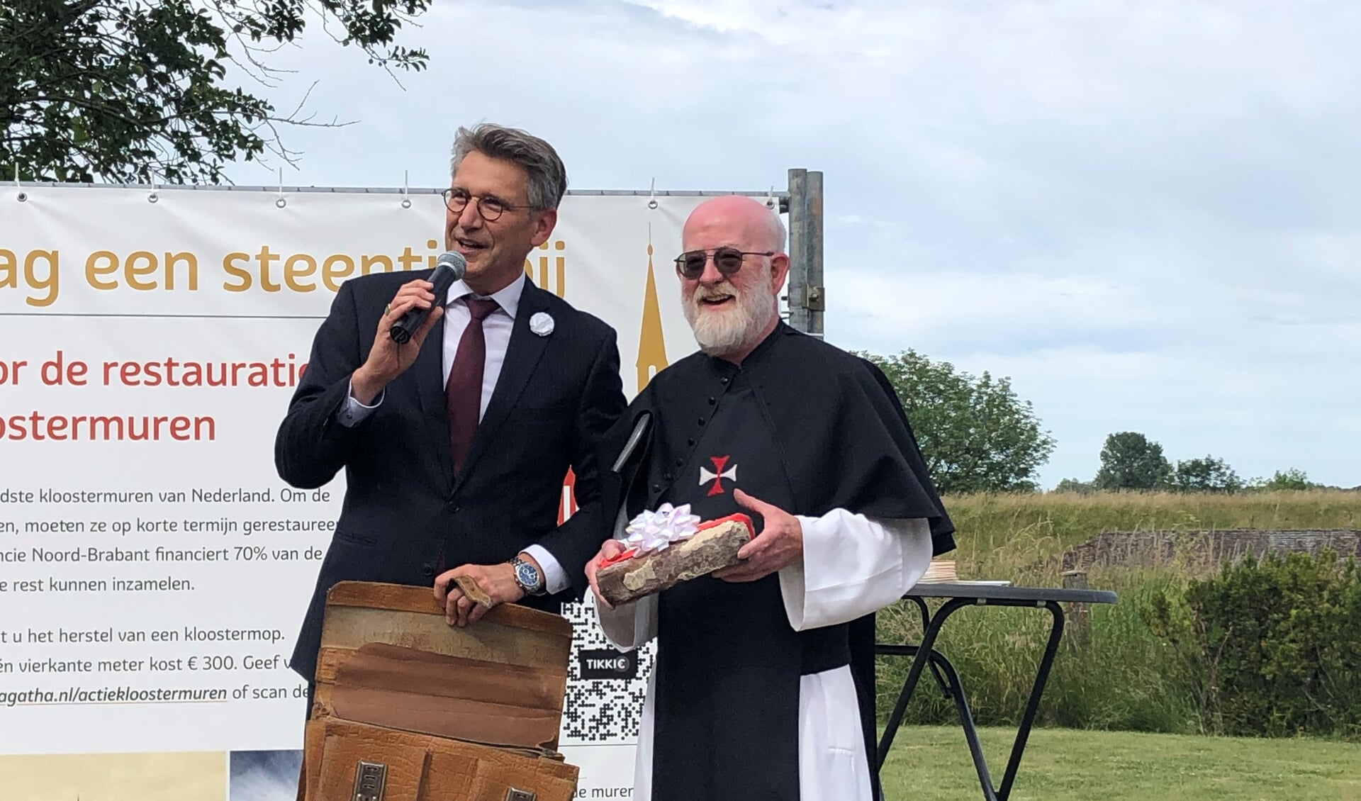 Kruisheer Edgard Claes heeft zojuist een echte kloostmop gekregen van waarnemend burgemeester Wim Hillenaar. De fondsenwerving voor de restauratie van de kloostermuren in Sint Agatha, is officleel afgetrapt.