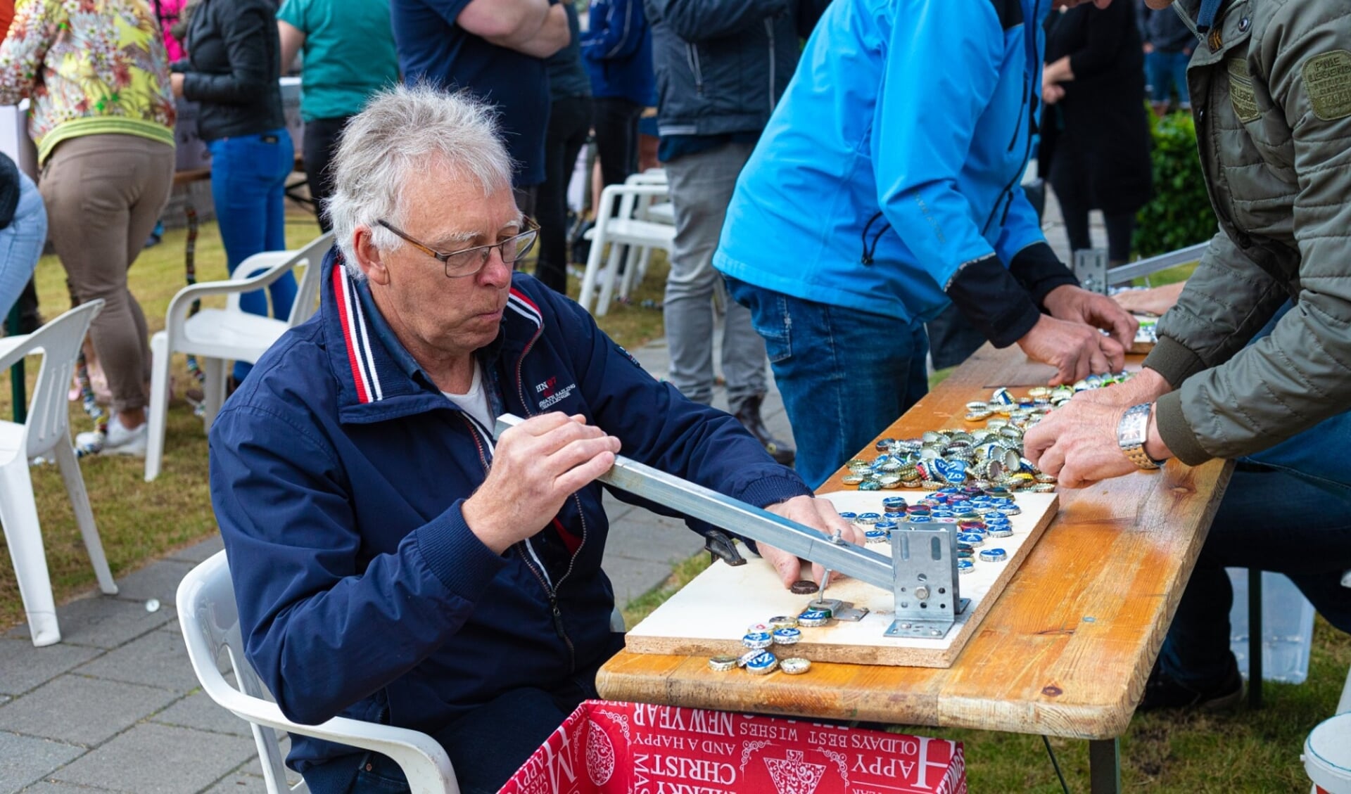 De kroonkurken worden voorbereid door er gaatjes in te drukken.