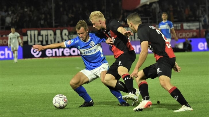Rik Mulders in actie tegen twee verdedigers van Almere City FC.
