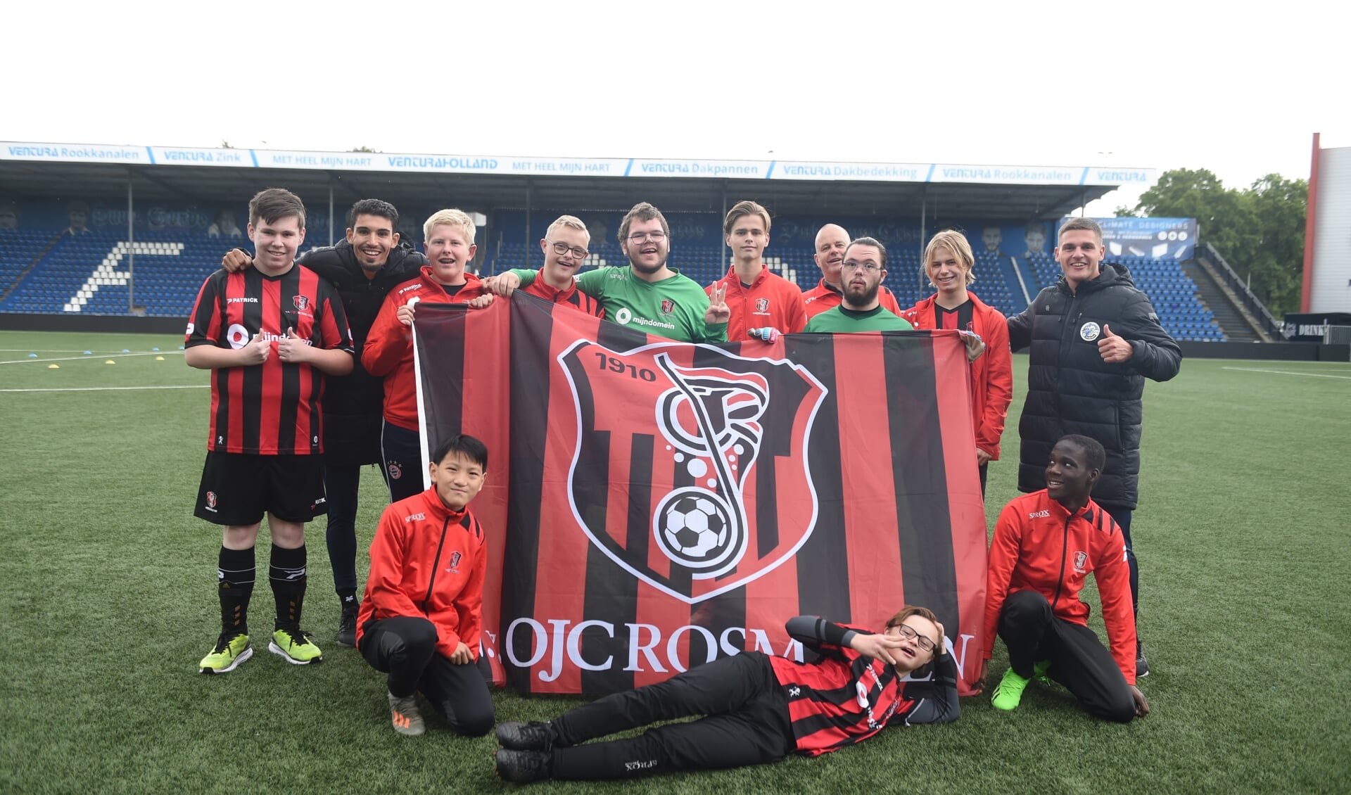 Een team van OJC Rosmalen poseert met FC Den Bosch-spelers Faris Hammouti (tweede van links links) en Jordy van der Winden (rechts).