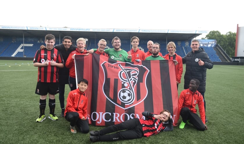 <p>Een team van OJC Rosmalen poseert met FC Den Bosch-spelers Faris Hammouti (tweede van links links) en Jordy van der Winden (rechts).</p>