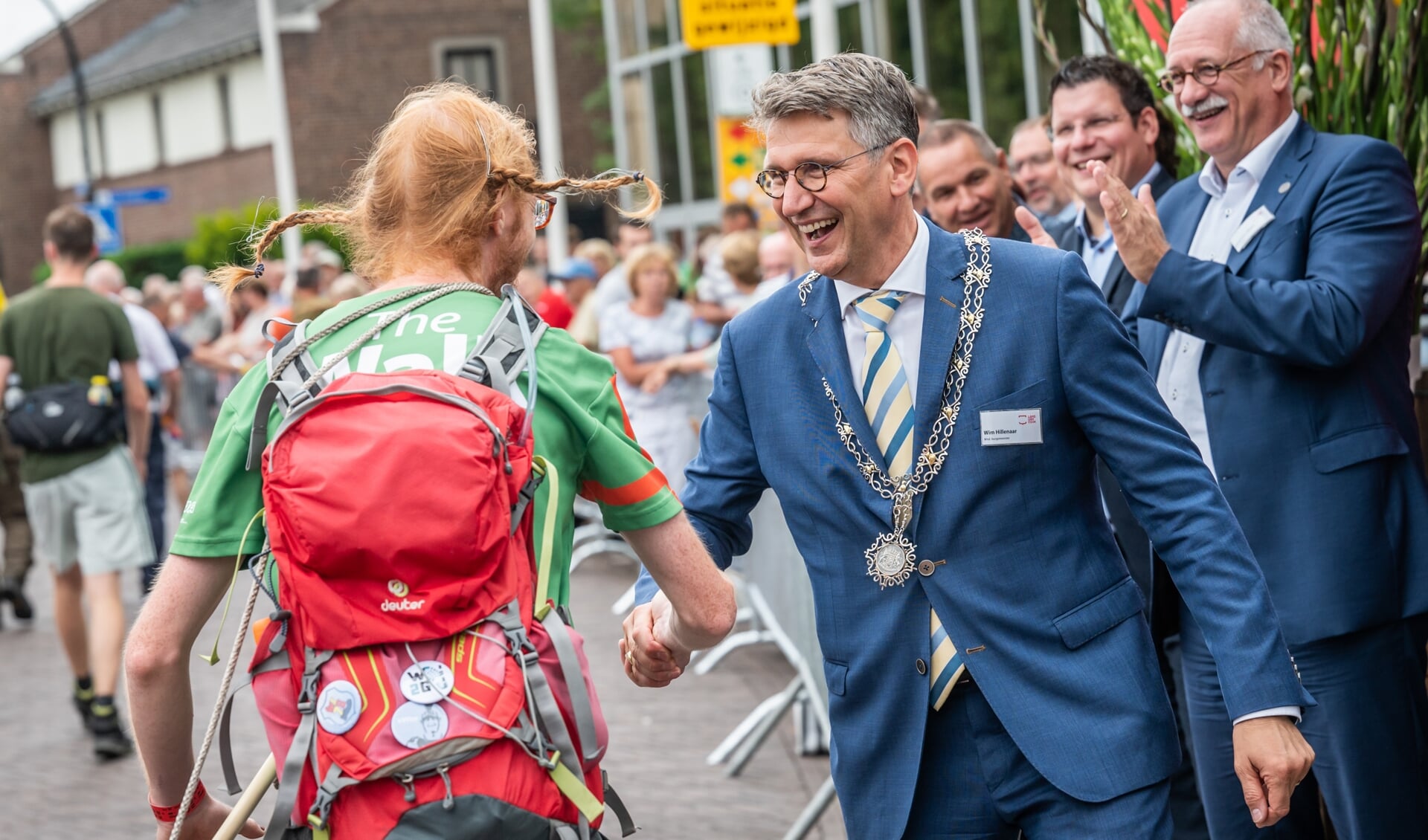 Wim Hillenaar schudt in Cuijk de handen met een Vierdaagseloper.