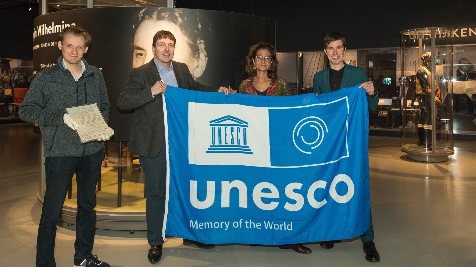 De voorzitter van het UNESCO Comité, Kathleen Ferrier (tweede van links) rijkt de UNESCO-vlag uit aan het Oorlogsmuseum. (Foto: Albert Hendriks)