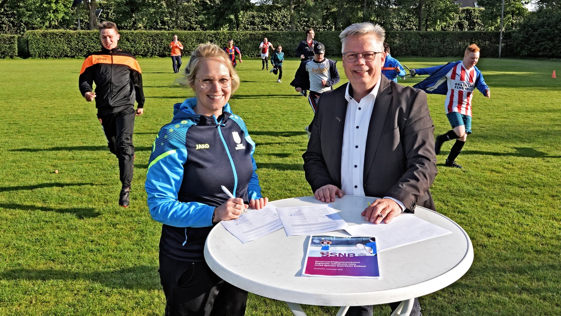 Anne van Melis van SSNB en wethouder Harold van den Broek (Sport) ondertekenen de overeenkomst Uniek Sporten tijdens de training van het G-team van Udi'19.